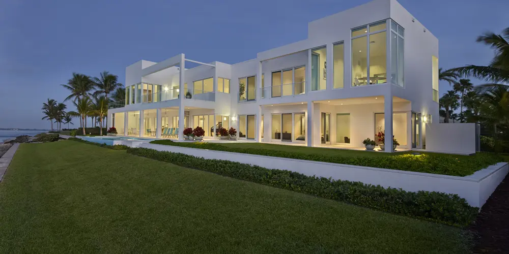 The expansive waterfront facade features large glass windows that maximize the panoramic views. The clean lines and terrace spaces enhance the modern aesthetic, seamlessly merging the indoor and outdoor environments.
