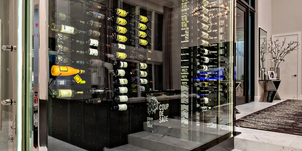This striking glass-enclosed wine cellar is both a functional and aesthetic focal point, positioned to enhance the modern luxury of the home. The display maximizes transparency while maintaining a sense of exclusivity and sophistication.