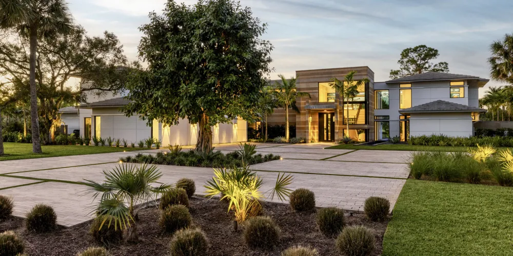  A sophisticated entryway framed by lush landscaping leads to the home. The integration of natural elements with modern architecture creates a welcoming and aesthetically pleasing first impression.