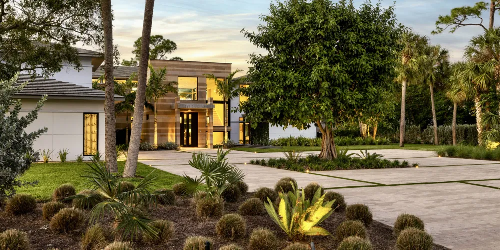 This image captures the beautifully landscaped approach to the home, with native plants enhancing the architectural design. The carefully curated greenery contributes to the home's natural charm.