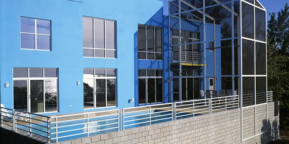 Discover the allure of vibrant architecture with bold yellow and blue exterior elements. This striking design exemplifies modern creativity and tranquility, paired with texture contrasts for a captivating contemporary appeal.