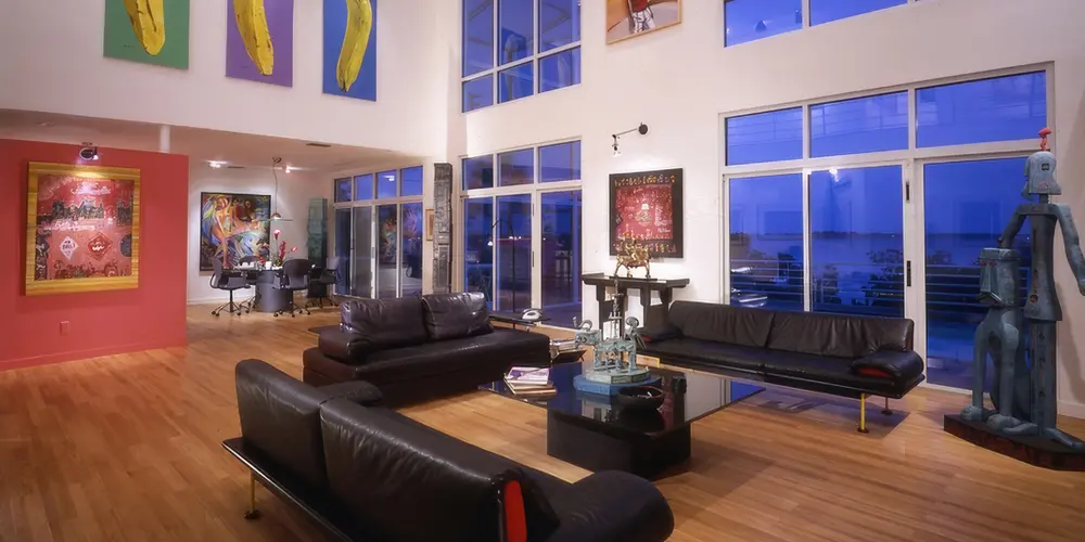 Immerse yourself in a gallery-inspired living space that marries neutral tones with vibrant artwork. Modern design meets culture with refined wooden floors and sleek leather furniture, creating an inviting environment that celebrates creativity.