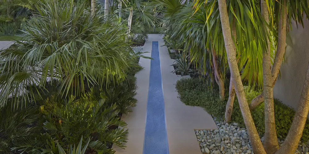 This picturesque walkway is lined with lush greenery and a linear water feature, offering a tranquil escape within the garden. The pathway design promotes relaxation and harmony.
