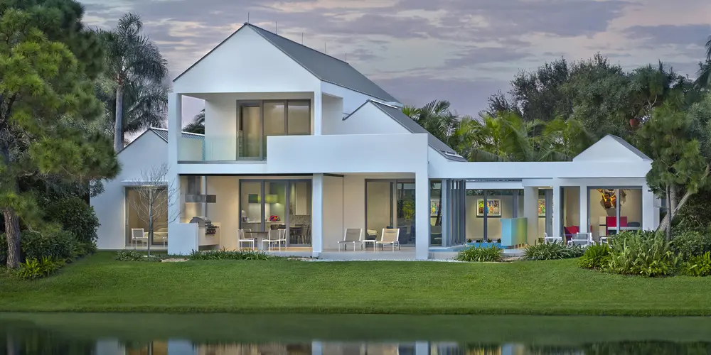 The architectural symmetry of the rear design is meticulously crafted, featuring clean lines, white facades, and generous glass openings that harmonize with the surrounding landscape.
