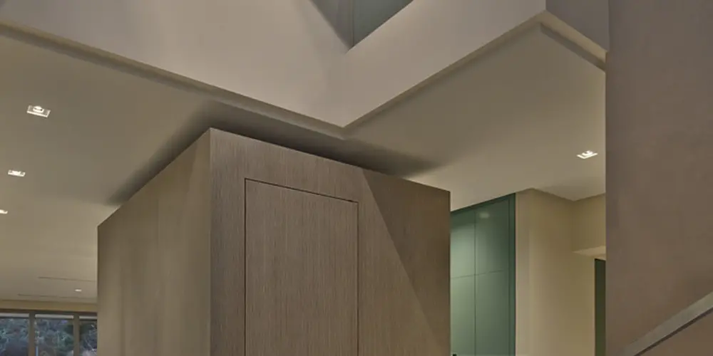 This foyer combines sleek lines and minimalist design with artistic flair, highlighted by a wall mural. Glass railings and light wood textures create a sophisticated, airy atmosphere.
