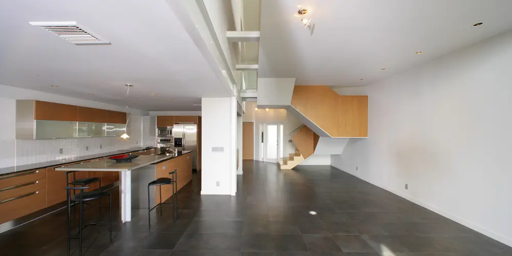 A panoramic view highlights the unity of the kitchen and stairway, illustrating a clever use of space. 