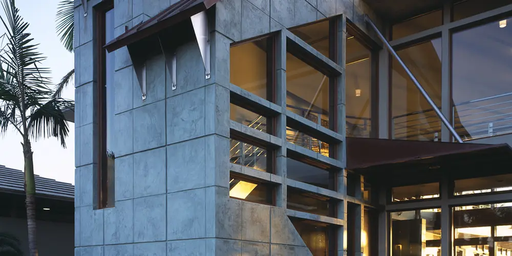 The exterior facade showcases sophisticated modern architecture with a focus on clean lines, textured surfaces, and striking angular features. The use of natural materials like stone complements the architectural design, providing a harmonious blend of form and function.

